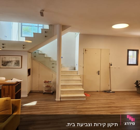 פנים בית עם מדרגות, קירות צבועים ורצפת עץ